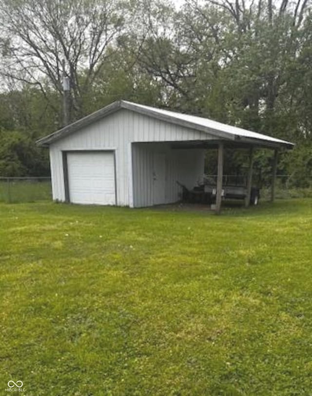 garage featuring a detached garage and fence