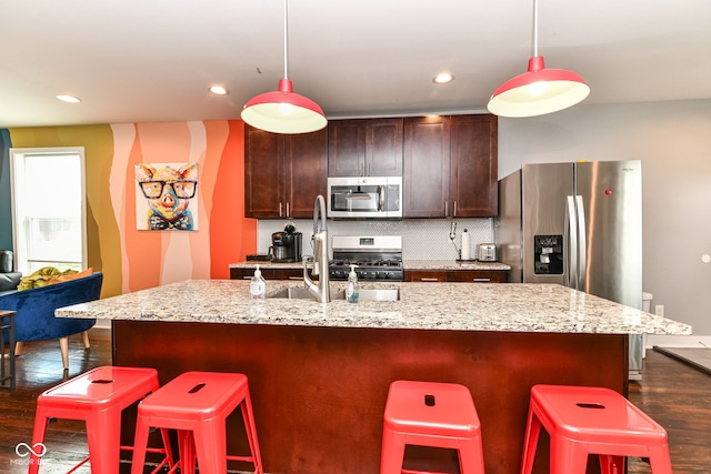 319 S Randolph St, Indianapolis, IN 46201 - kitchen with appliances with stainless steel finishes, dark wood-style floors, a kitchen breakfast bar, tasteful backsplash, and pendant lighting