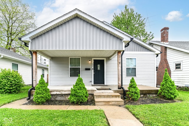 319 S Randolph St, Indianapolis, IN 46201 - bungalow-style home featuring board and batten siding, a porch, and a front yard