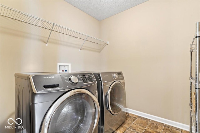 washroom featuring washer and dryer, laundry area, and baseboards