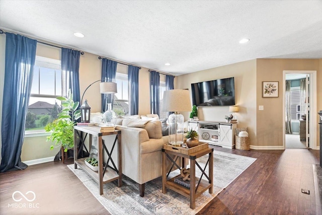 living room featuring recessed lighting, a textured ceiling, dark wood finished floors, and baseboards