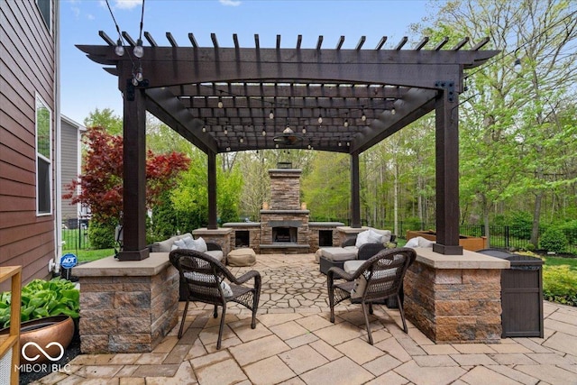 view of patio with an outdoor stone fireplace and a pergola