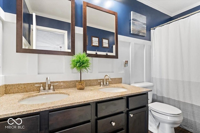 full bath with crown molding, a sink, a decorative wall, and toilet