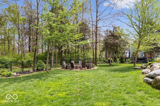 view of yard featuring an outdoor fire pit and fence