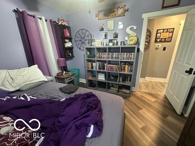 bedroom with baseboards and wood finished floors