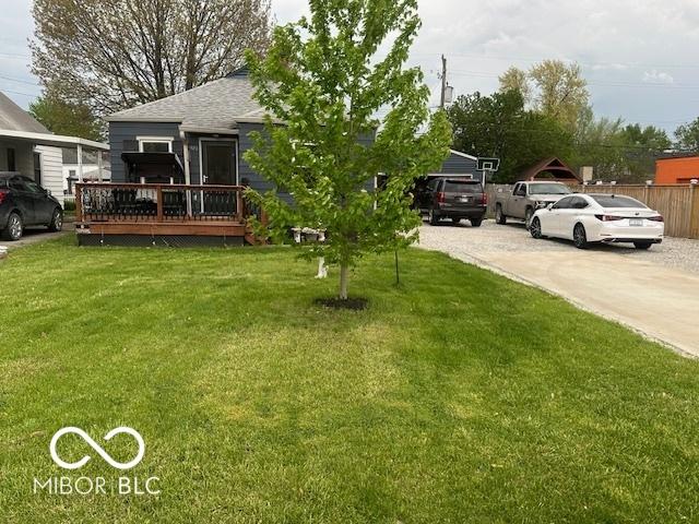 view of yard featuring driveway and a wooden deck