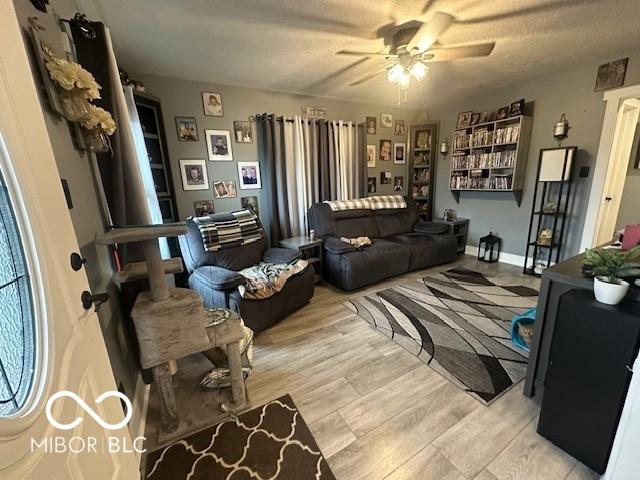 living room with light wood finished floors and ceiling fan