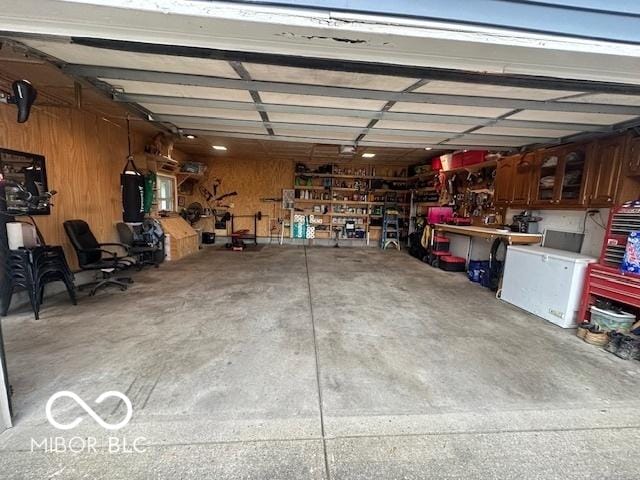 garage with wooden walls and a workshop area