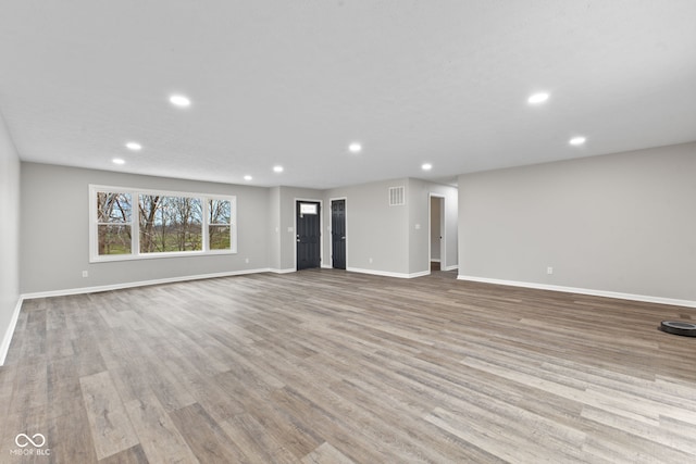 unfurnished living room featuring recessed lighting, baseboards, and wood finished floors
