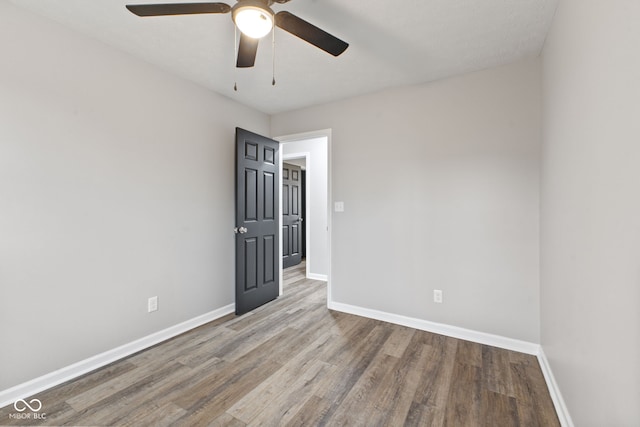 spare room featuring a ceiling fan, baseboards, and wood finished floors