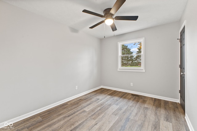 spare room featuring baseboards, a ceiling fan, and wood finished floors