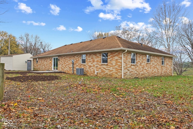 back of property featuring central air condition unit, roof with shingles, and brick siding