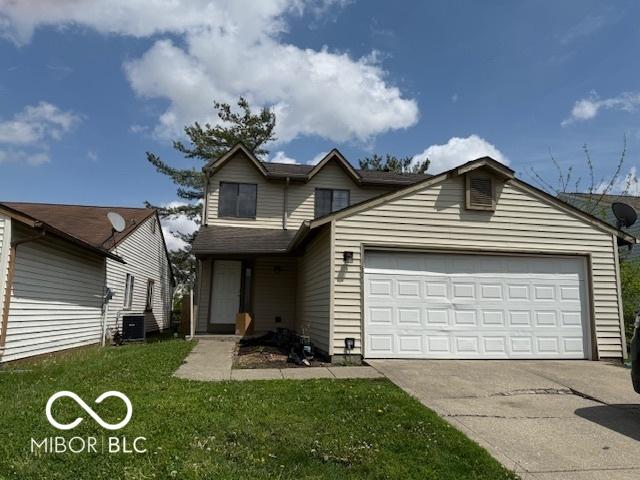 traditional-style house featuring a garage, central air condition unit, concrete driveway, and a front yard