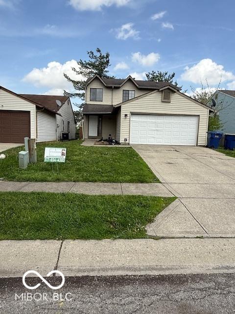 view of front facade featuring a garage, driveway, and a front yard