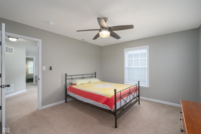 bedroom with baseboards, multiple windows, light colored carpet, and visible vents