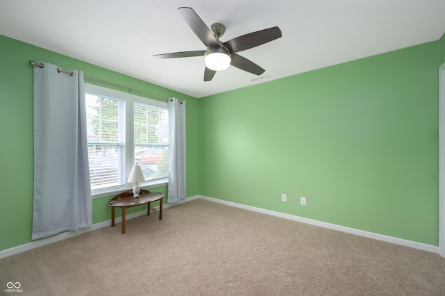spare room featuring a ceiling fan, baseboards, visible vents, and light carpet
