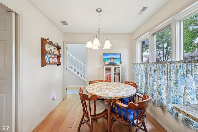 1030 Stratford Hall Unit 17-3, Indianapolis, IN 46260 - dining space featuring a chandelier, light wood finished floors, stairs, and baseboards