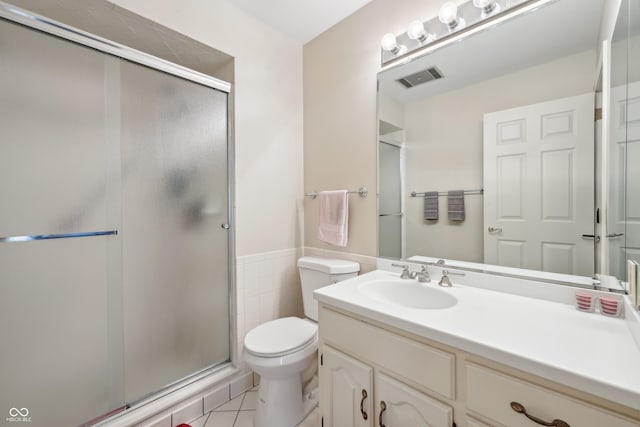 1030 Stratford Hall Unit 17-3, Indianapolis, IN 46260 - bathroom featuring a stall shower, toilet, tile patterned flooring, vanity, and a wainscoted wall