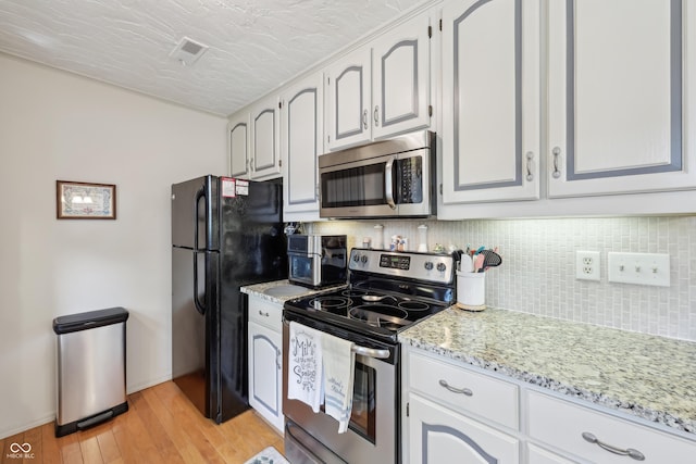 1030 Stratford Hall Unit 17-3, Indianapolis, IN 46260 - kitchen featuring stainless steel appliances, backsplash, light wood-type flooring, light stone countertops, and a textured ceiling