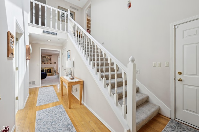 1030 Stratford Hall Unit 17-3, Indianapolis, IN 46260 - stairs with ornamental molding, wood finished floors, a brick fireplace, and baseboards