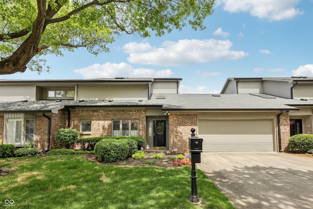 1030 Stratford Hall Unit 17-3, Indianapolis, IN 46260 - view of front facade featuring a garage, brick siding, a front lawn, concrete driveway, and a shingled roof