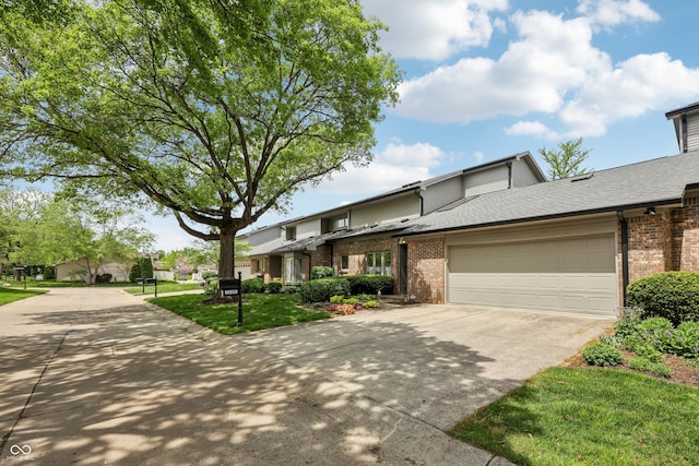 1030 Stratford Hall Unit 17-3, Indianapolis, IN 46260 - view of front of home with brick siding, driveway, an attached garage, and a shingled roof