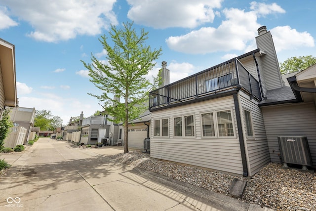 1030 Stratford Hall Unit 17-3, Indianapolis, IN 46260 - view of property exterior featuring a balcony, central AC, a chimney, a residential view, and a garage
