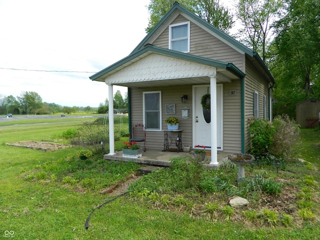 bungalow-style home featuring covered porch and a front yard