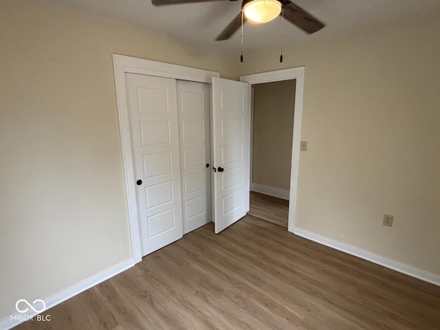 unfurnished bedroom featuring a closet, baseboards, a ceiling fan, and light wood-type flooring