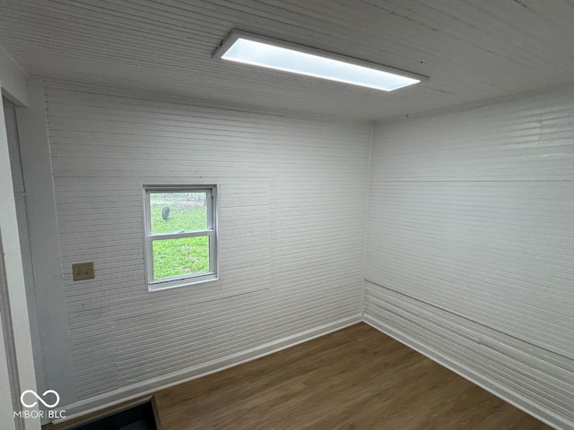 unfurnished room with baseboards and dark wood finished floors