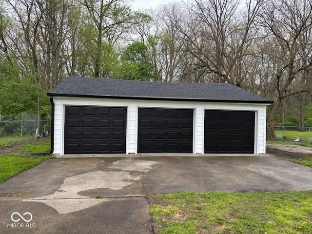 detached garage featuring fence