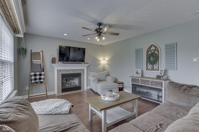 living room featuring wood finished floors, a fireplace, baseboards, ceiling fan, and recessed lighting