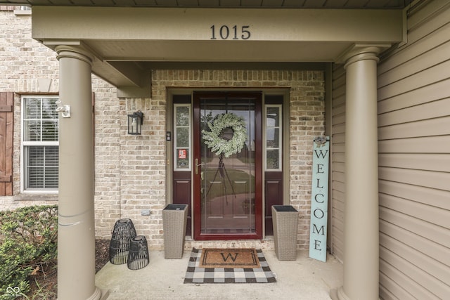 entrance to property featuring brick siding