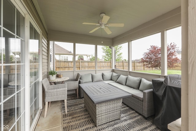 sunroom featuring a ceiling fan, outdoor lounge area, and a wealth of natural light