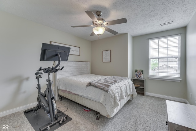 bedroom featuring carpet floors, a textured ceiling, a ceiling fan, baseboards, and visible vents