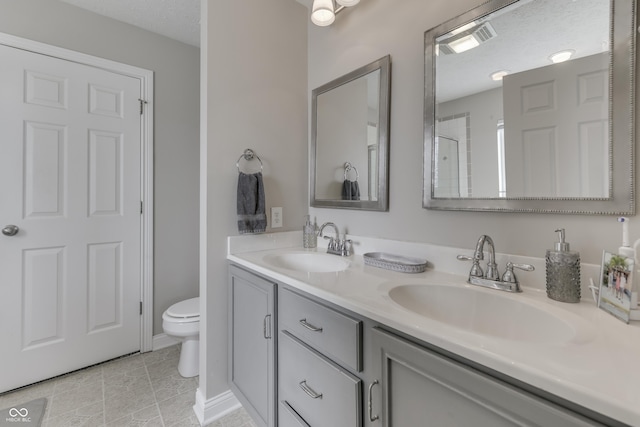 full bath featuring double vanity, a sink, visible vents, and toilet