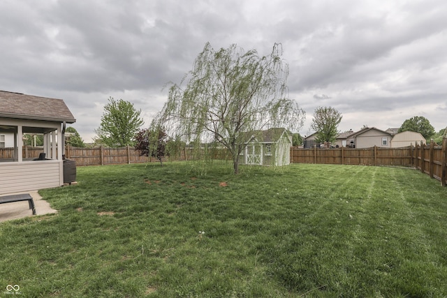 view of yard featuring a fenced backyard, an outbuilding, and a storage shed