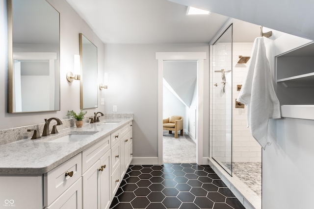 bathroom featuring double vanity, tiled shower, a sink, and tile patterned flooring