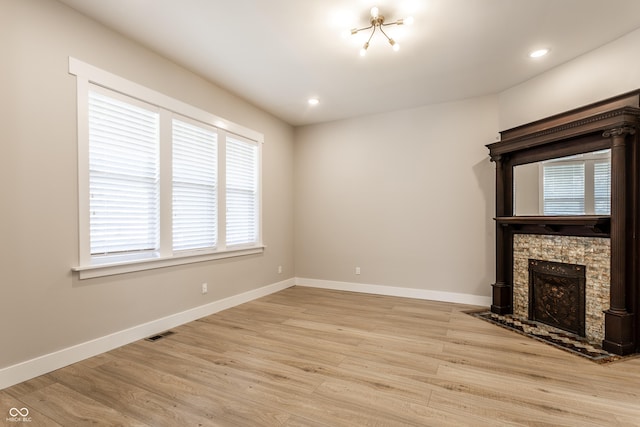unfurnished living room featuring visible vents, a fireplace, light wood-type flooring, baseboards, and recessed lighting