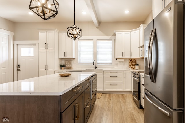 kitchen featuring a sink, white cabinetry, appliances with stainless steel finishes, and decorative backsplash