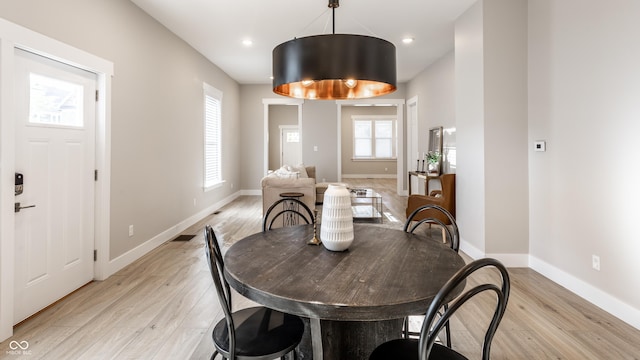 dining space with baseboards, recessed lighting, and light wood-style flooring