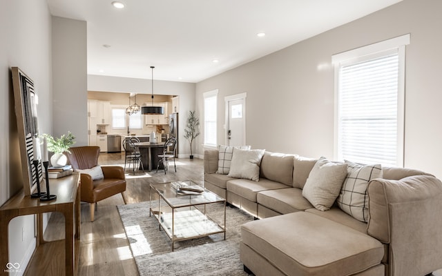 living room featuring recessed lighting, baseboards, and light wood finished floors