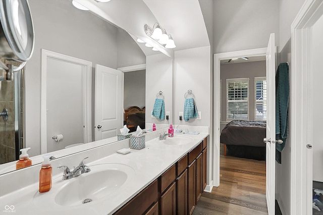 full bathroom with ensuite bath, double vanity, wood finished floors, and an enclosed shower