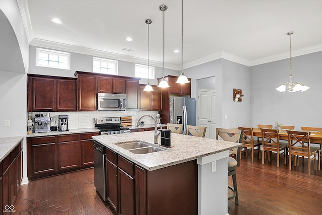 kitchen featuring stainless steel appliances, a sink, a breakfast bar, dark wood-type flooring, and decorative backsplash