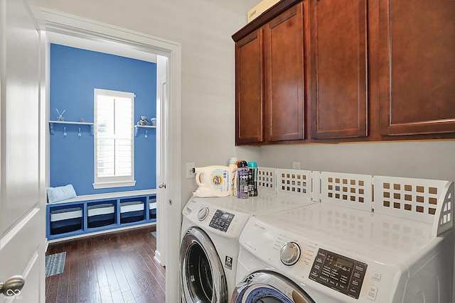 laundry area featuring washer and dryer, cabinet space, and dark wood-type flooring