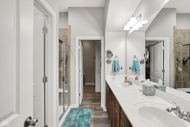 full bath with a shower stall, wood finished floors, and double vanity