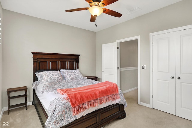 bedroom featuring light carpet, baseboards, ceiling fan, and a closet