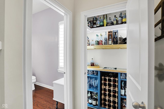 indoor dry bar featuring wood finished floors, plenty of natural light, baseboards, and wine cooler