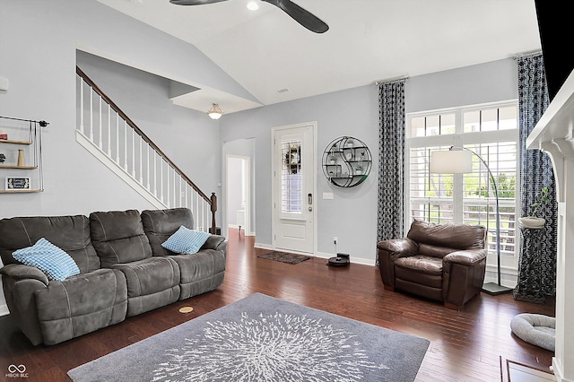 living area featuring healthy amount of natural light, ceiling fan, lofted ceiling, wood finished floors, and stairway