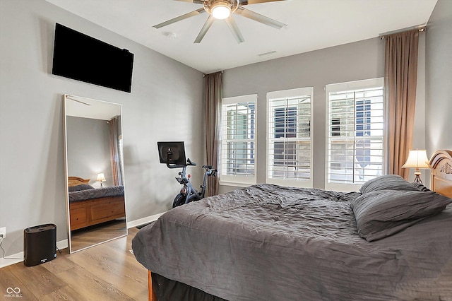 bedroom featuring wood finished floors, ceiling fan, and baseboards